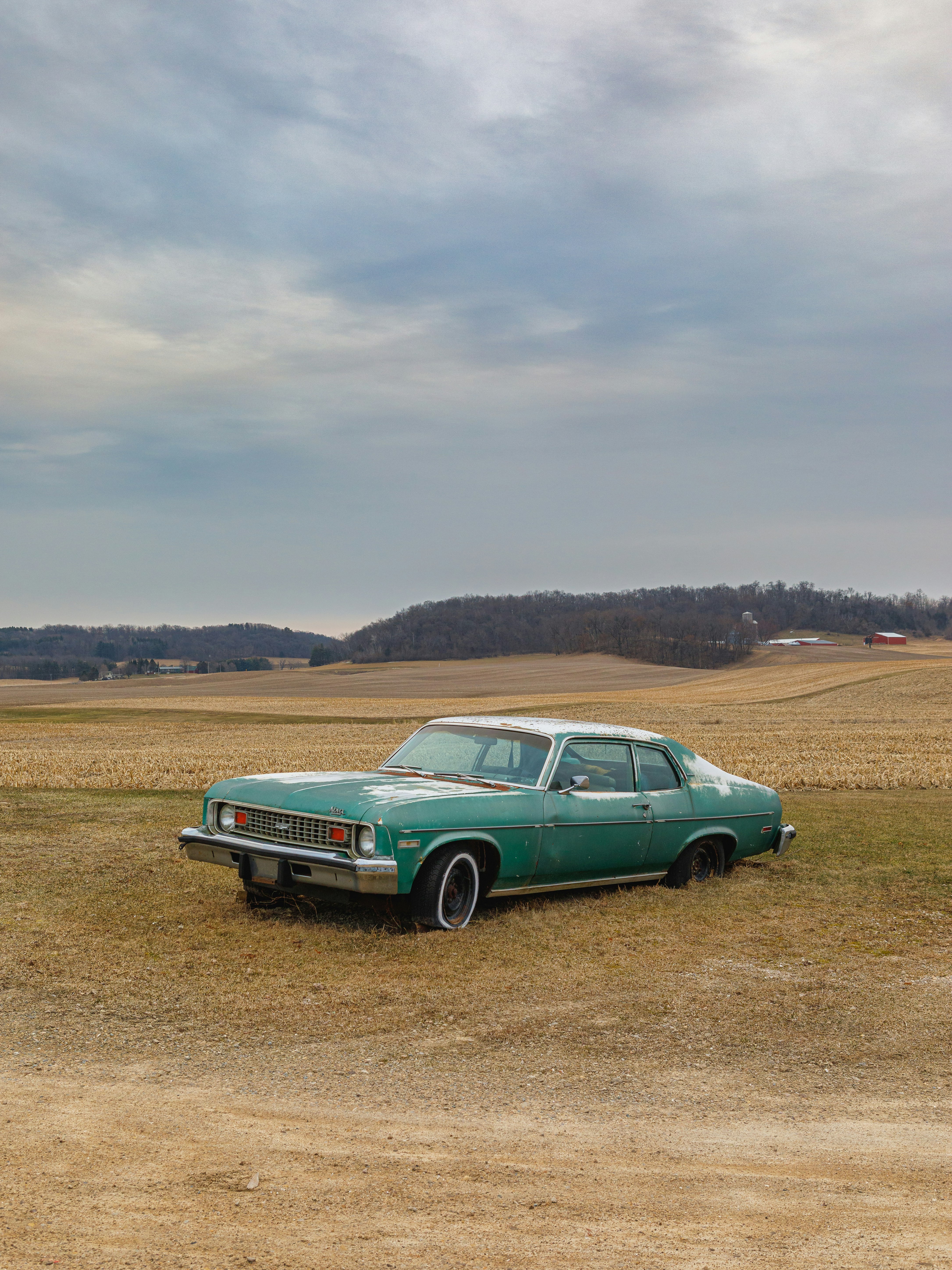 green car on brown field during daytime